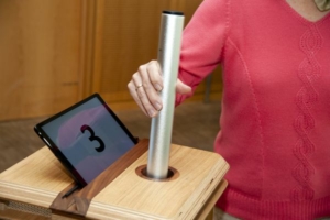 A woman registers her baton at the station with the number 3 on it